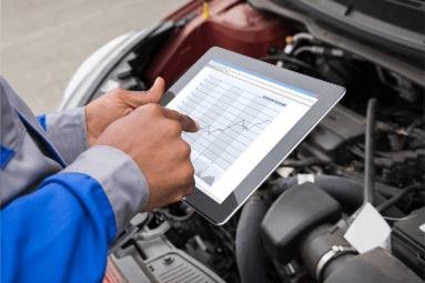 hands holding a tablet to assess car health