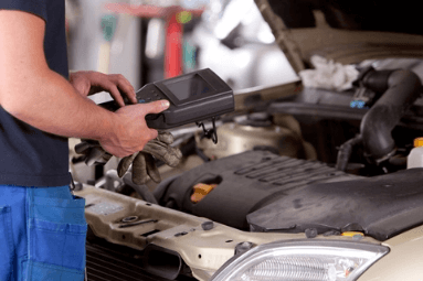 mechanic checking car with tool